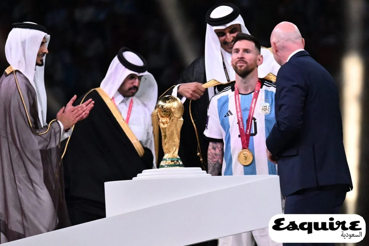 Lionel Messi wears a black bisht beside the World Cup trophy during the 2022 final ceremony.