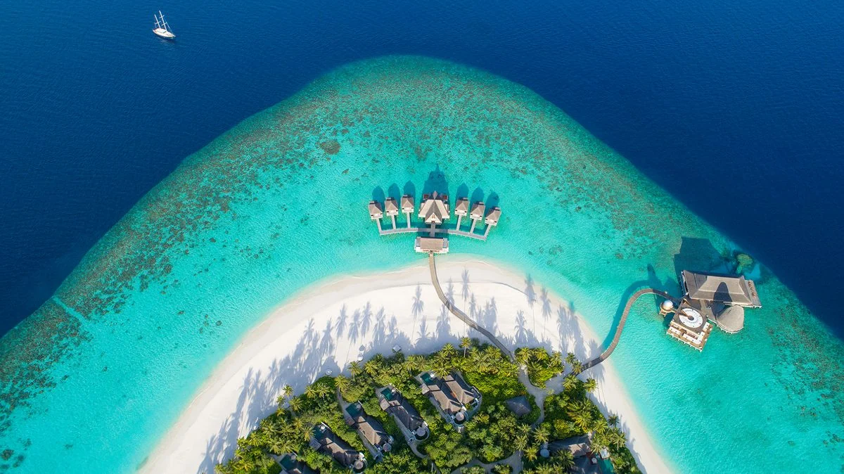 Aerial view of Anantara Kihavah Maldives villas over a turquoise lagoon.