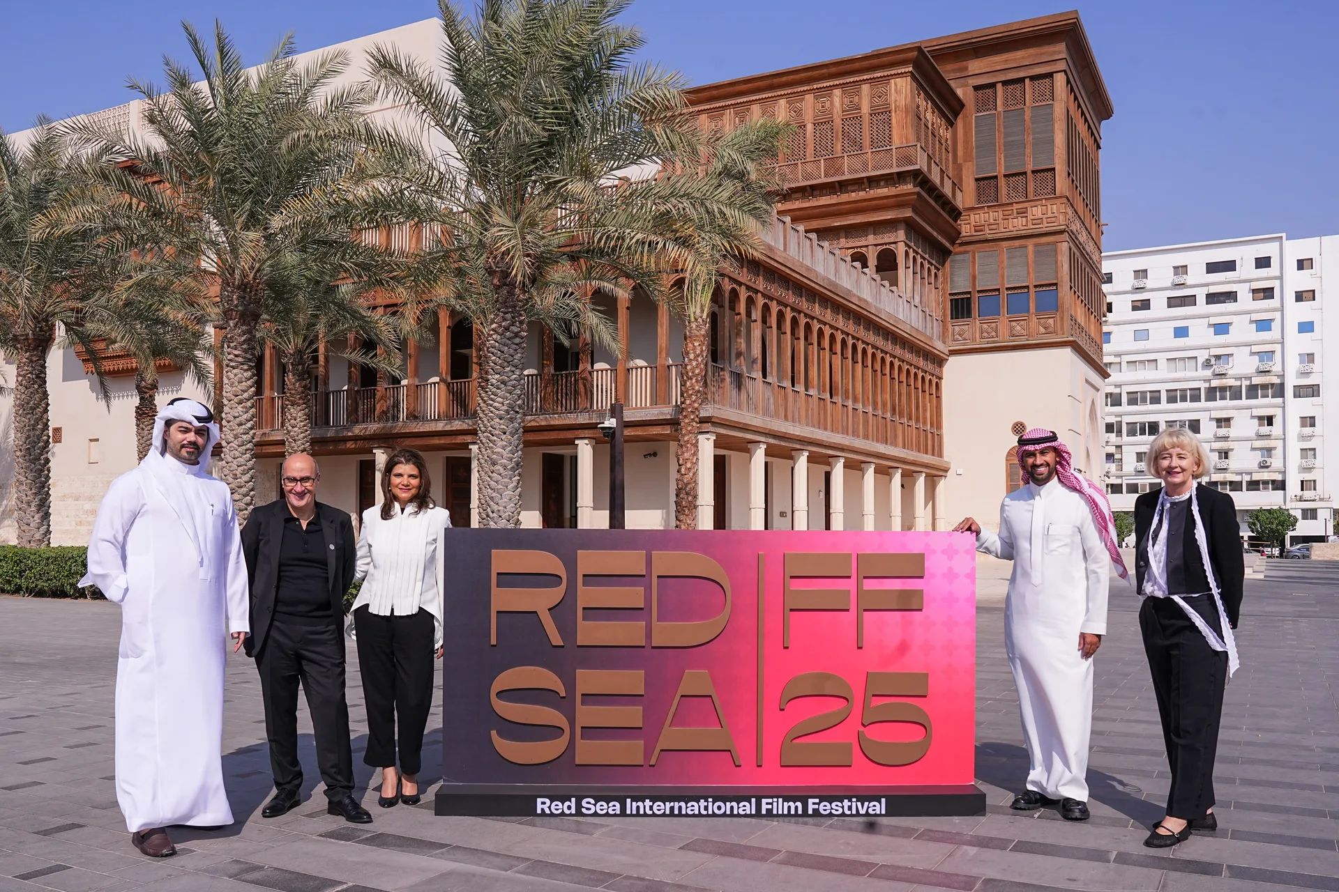Five guests stand together beside a Red Sea Film Festival sign in Historic Jeddah.
