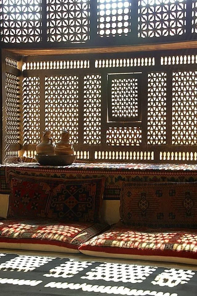 Historic Jeddah roshan screen filtering daylight into geometric shadow.