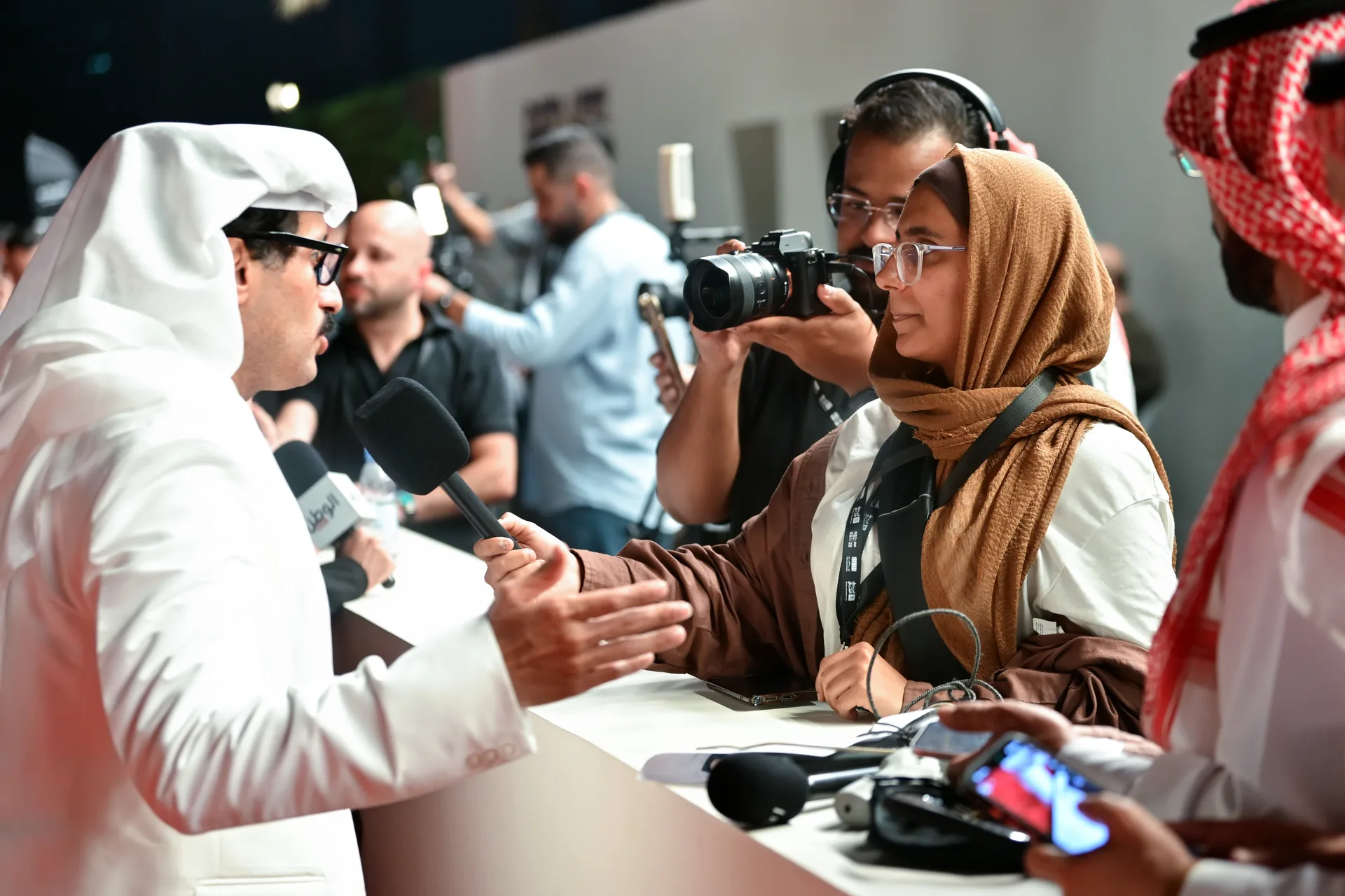 A journalist interviews a Festival guest while a camera operator records the exchange.
