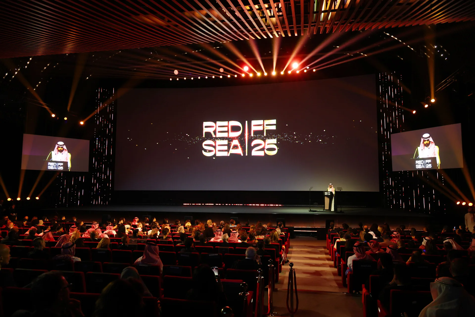 An audience faces the Red Sea Film Festival stage and fifth-edition screen.