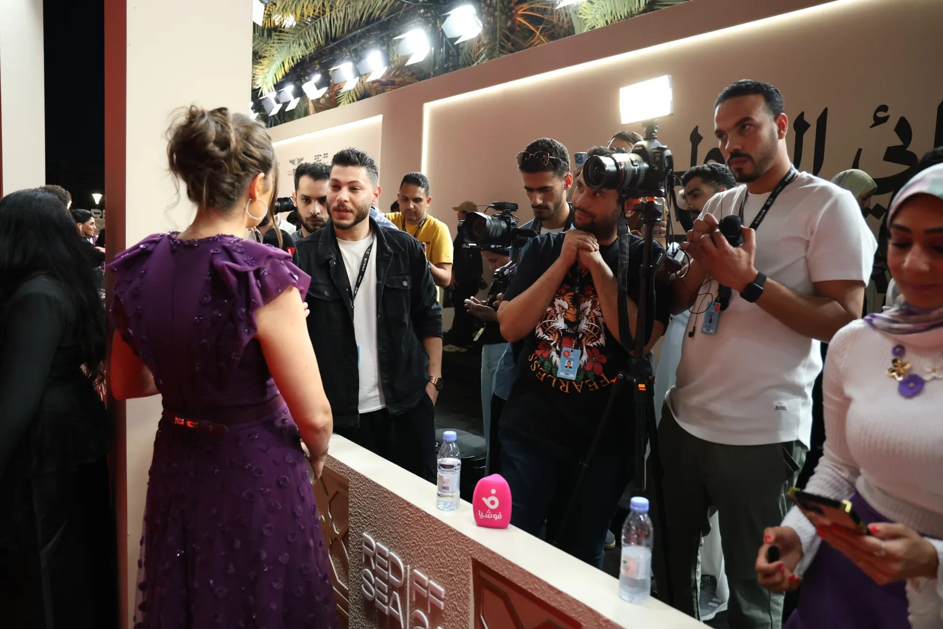 A Festival guest speaks with reporters and camera crews at the press line.